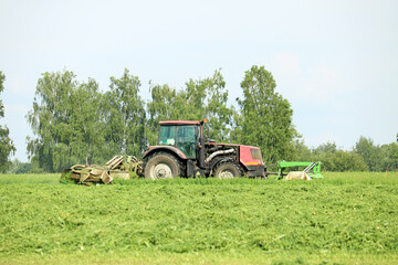 Obraz premium tractor mows green grass 