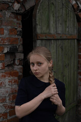 A beautiful young girl in the village, with an old washingboard, ethnos, against the background of the old wood doors