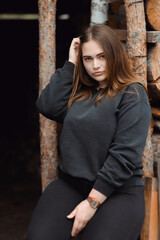 Shot of an attractive young woman sitting in front of wooden background. High quality photo