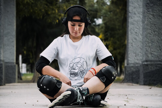Joven mujer skater est&aacute; en el suelo descansando