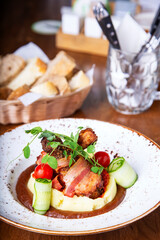 Baked chicken leg in bacon with potato puree. Closeup