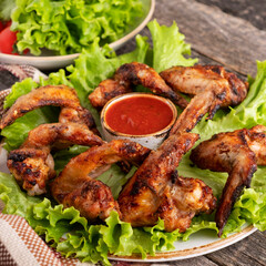 Bbq chicken wings garnish with red sauce. Closeup