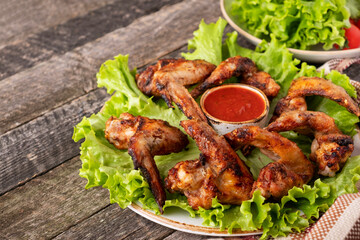 Fototapeta premium Grilled chicken wings garnish with red sauce. Copy space
