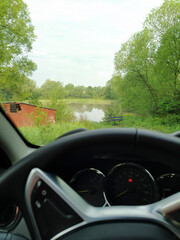 image of the steering wheel of a car and view through the windshield