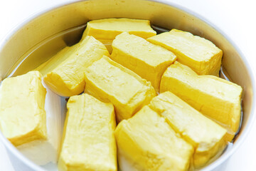 the yellow tofu in a basket filled with water. isolated white background