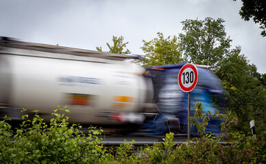 Schild mit der Geschwindigkeitsbegrenzung Tempo 130 auf einer deutschen Autobahn, dahinter ein LKW...