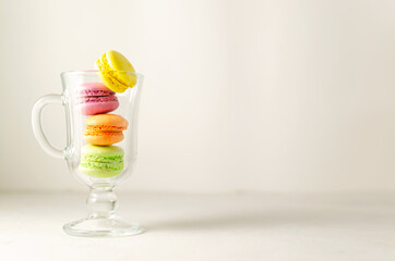 Delicious sweet cookies, colored cakes with macaroons in a transparent glass cup. White background. summer cocktail concept. close-up with place for text