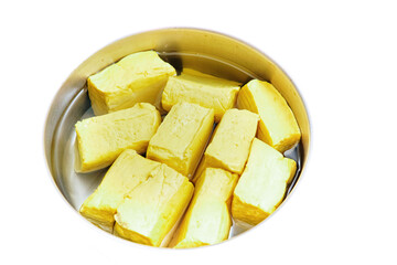 the yellow tofu in a basket filled with water. isolated white background