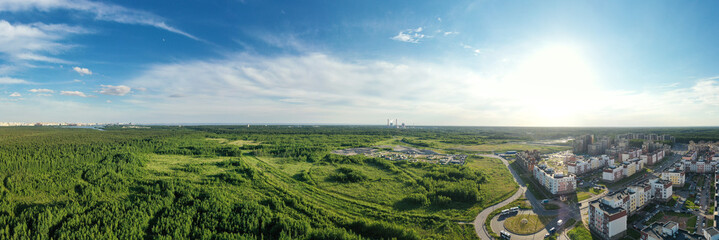 Summer forest and green field near city. Panorama