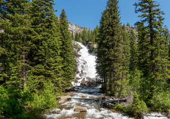 Fototapeta na wymiar Large waterfall in the mountain forest in summer