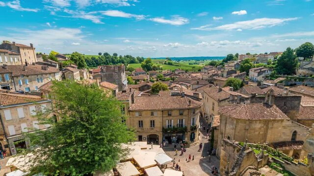Timelapse of wide angle view of the medieval town of Saint Emilion, Dordogne, Aquitaine, France. Zoom out from horizon on roof top