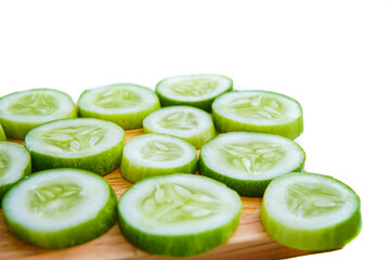 slices of fresh green cucumber on a cutting board. isolated white background