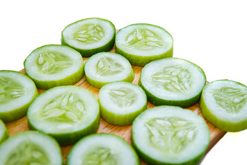 slices of fresh green cucumber on a cutting board. isolated white background