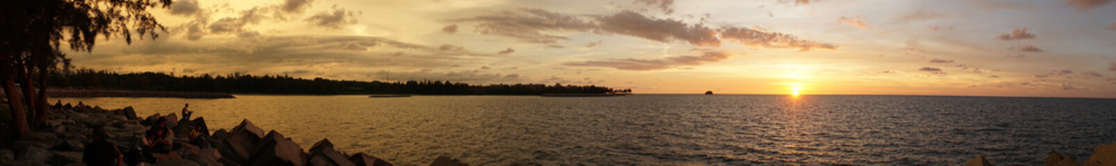 Fototapeta na wymiar Sunset over the ocean with clouds and orange sky at Bandar Seri Begawan, Brunei.
