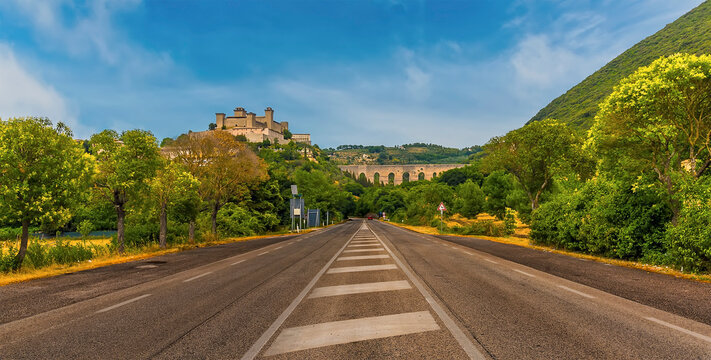 A view down the highway towards the Tower Bridge and the hill top fortress in Spoleto, Italy in summer