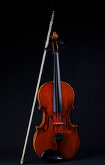 Fototapeta na wymiar Eine Violine mit Violinbogen auf schwarzem Grund