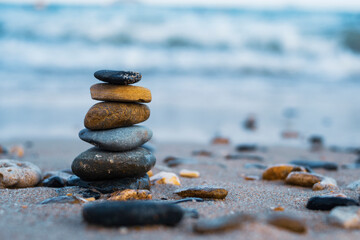 Pebbles are piled on a volcanic rock by the sea. Zen concept. Copy space
