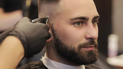 Hairdresser with trimmer doing haircut at hair salon or barber shop. Beauty, hairstyle and people concept.