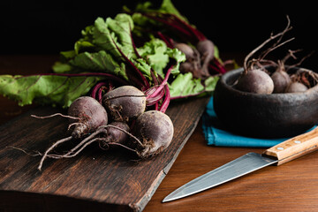 Fresh raw organic beetroot with leaves over a wood cutting board