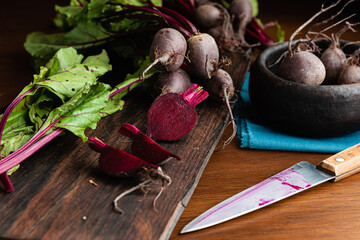 Fresh raw organic choped beetroot with leaves over a wood cutting board