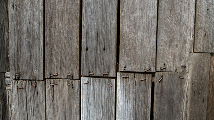 Background pattern: old weathered hardwood planks fastened to a wall with bent rusty nails.