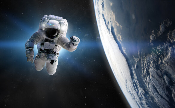 Astronaut at spacewalk. Concept of conquering the universe by the human race. Elements of this image furnished by NASA