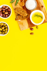 Appetizer. Olives in bowl and bread on cutting board from above space for text