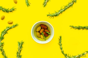 Mixed olives in bowl and rosemary branches top view