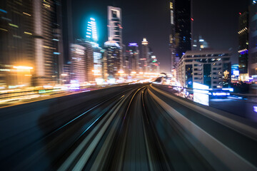 Fototapeta na wymiar Tran running on rails in a night city., blurred motion with light.