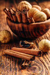 Cinnamon sticks and dried limes in wooden bowl