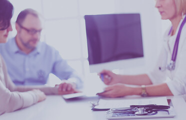 Doctor in clinic asking senior woman in wheelchair for a signature