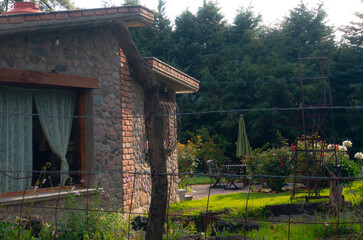 Casa de campo con arboles y flores dia soleado y cercado