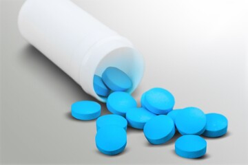 Medical colored pills in the plastic bottle on the desk