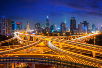 Fototapeta na wymiar Shanghai elevated road junction and interchange overpass with office building skyscrapers downtown district at night in Shanghai, China. Asian tourism, modern city life, or business finance concept