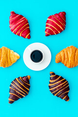 Set of coffee with croissants - chocolate, berry, classic - on blue stone table