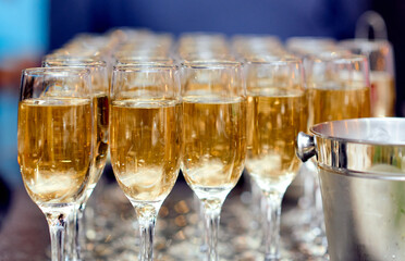 lots of champagne glasses on the table with an ice bucket