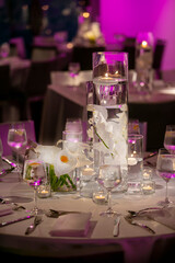 Obraz na płótnie Canvas Floating candles on a dimly lit wedding ceremony table with flowers