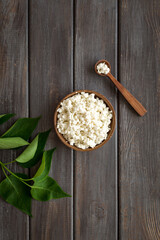 Breakfast still life. Cottage cheese in bowl, green branch top view