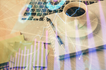 Double exposure of forex chart drawing and desktop with coffee and items on table background. Concept of financial market trading