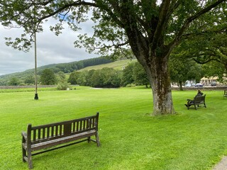 The large green in the village of Burnsall, with the river Wharfe in the distance in, Burnsall, Skipton, UK