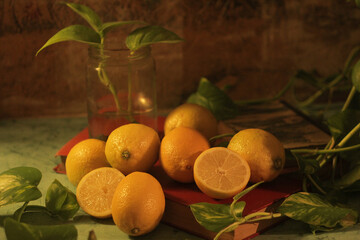 many healthy and natural juicy lemons on the table next to a jar with a plant and a potus...