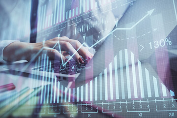 Double exposure of woman hands typing on computer and financial graph hologram drawing. Stock market analysis concept.