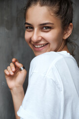 Beautiful girl smiling cute shyly. Close-up portrait of a beautiful young brunette woman in a white...