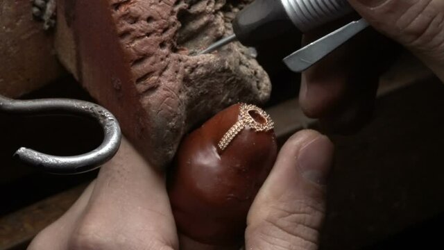 Production of diamond rings. Jeweler working in workshop. Craftsman jewelery making.  Jeweler making handmade jewelery. roze gold diamond ring. macro shooting emerald ring making 