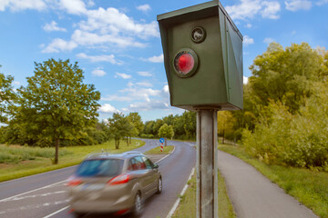 Speed control radar next to street with a car drive by