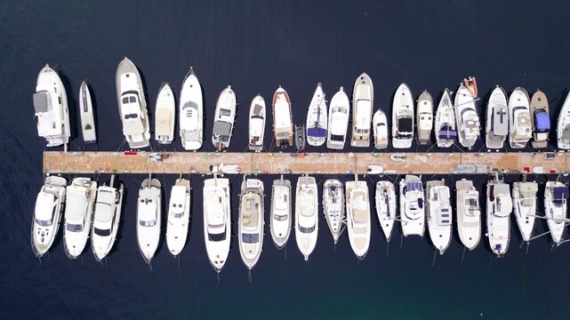 Aerial view of boats are parking at the pier by beautiful blue sea, drone shot.