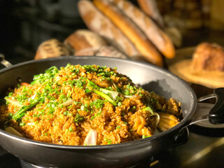 Garlic fried rice with vegetables on top and bread background