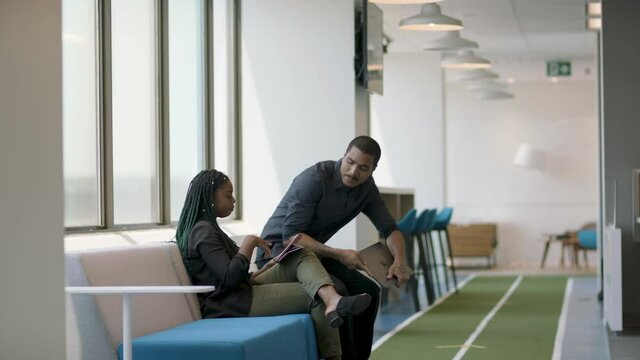 Let's chat. Hallway meeting takes place to collaborate on an ongoing project. Creative technology company working towards innovative project. Shot in slow-motion and in 4k. 