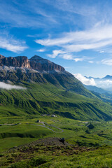 Summer morning in Dolomite Alps. Beautiful sunny landscape in the mountains. Ski hills of Piz Boe mountain in morning mist. View from Sella pass, Province of Trento, Italy, Europe.