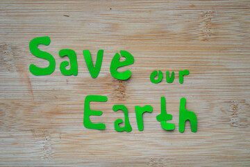 Phrase of Earth day. Saving our earth, go green, recycle symbol concept background on wooden board